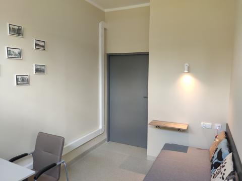 pokój odpoczynku z łóżkiem, oświetlonym stolikiem i systemem przywoławczym