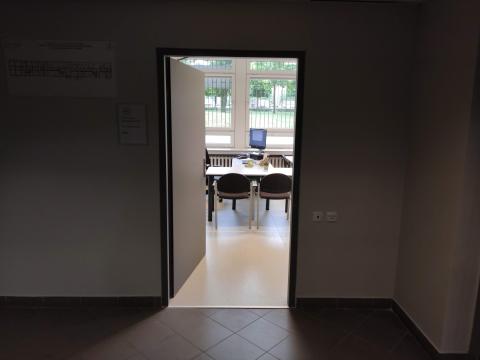 Wejście do biura, przez otwarte drzwi widać biurko
