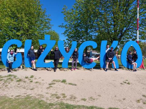 Duży napis Giżycko z uczestnikami pomiędzy literami