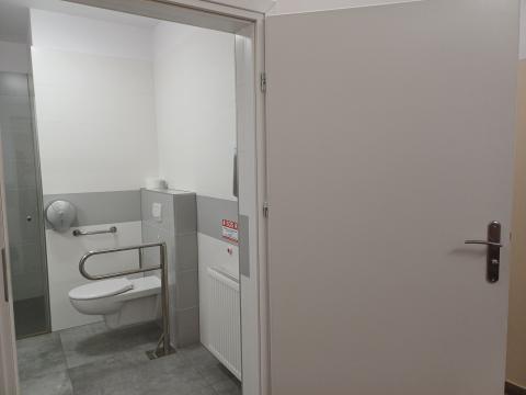 Otwarte drzwi do toalety. Muszla ustępowa