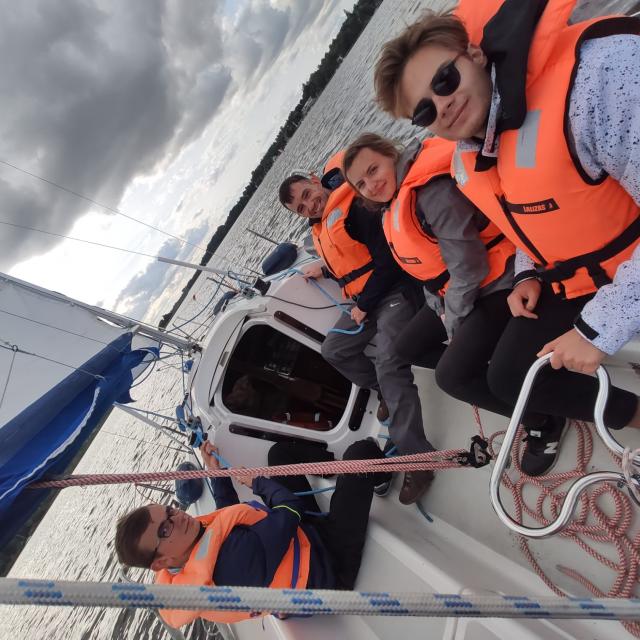 Uśmiechnięta grupa szkoleniowa na pokładzie jachtu
