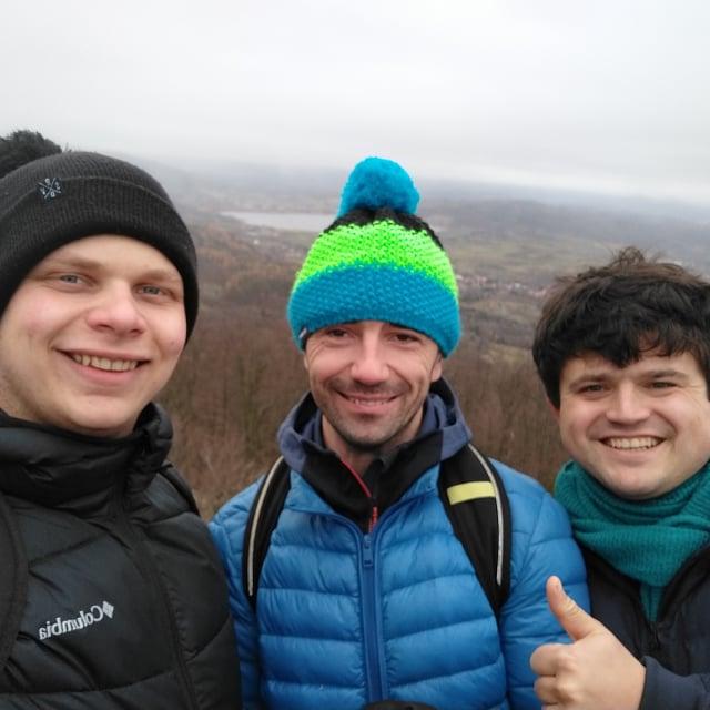 Troje uśmiechniętych przyjaciół pozuje na wieży zamku Chojnik