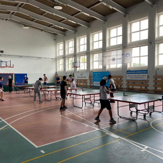 Uczestnicy grają w tenisa stołowego